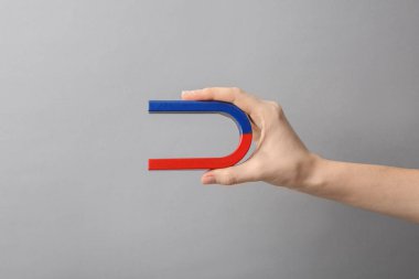 Gri arka plan üzerinde closeup mıknatıs tutan kadın. Metin için yer