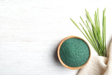 Spirulina tozu, çim ve beyaz arka plan, düz peçeteye kase yatıyordu. Metin için yer