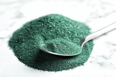 Mermer zemin, closeup üzerine kaşık ve spirulina tozu