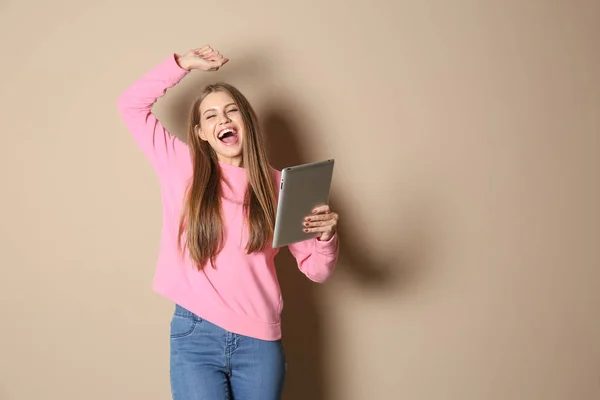 Emotionale Junge Frau Mit Tablet Feiert Sieg Auf Farbigem Hintergrund — Stockfoto