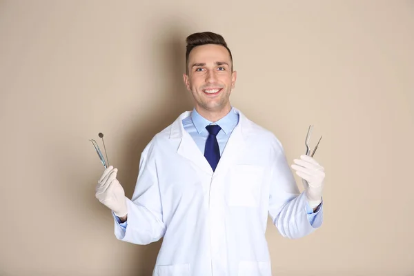 Мужчина Стоматолог Держит Профессиональные Инструменты Цветном Фоне — стоковое фото