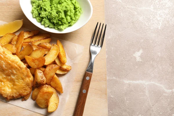 British traditional fish, potato chips and mushy peas on color background, top view. Space for text