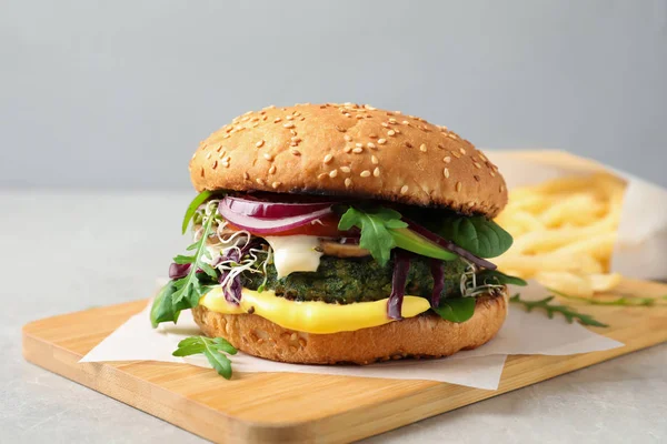 Board with tasty vegetarian burger on table