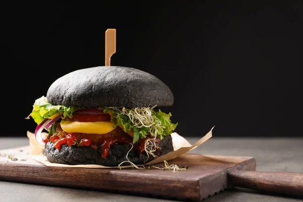 Bord Met Lekkere Zwarte Vegetarische Hamburger Tafel Tegen Donkere Achtergrond — Stockfoto