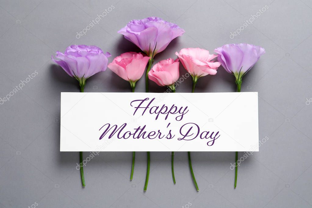 Beautiful eustoma flowers and text Happy Mother's Day on grey background, top view