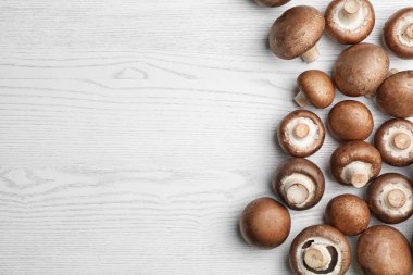 Ahşap masa üzerinde taze champignon mantar ile düz yatıyordu kompozisyon. Metin için yer