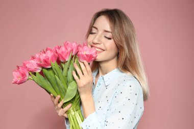 Bahar lale pembe bir arka plan üzerinde güzel gülümseyen kız portresi. Dünya Kadınlar günü