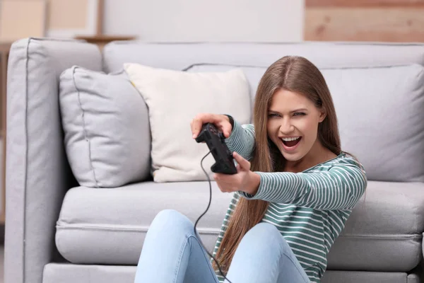 情绪激动的年轻女子在家玩电子游戏 — 图库照片