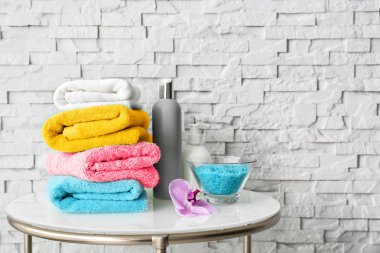Tuğla duvar, metin için yer yakınındaki masada renkli temiz yumuşak havlu yığını 
