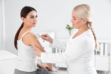 Dermatolog genç hastanın Doğum lekesi Büyüteç kliniği ile incelenmesi