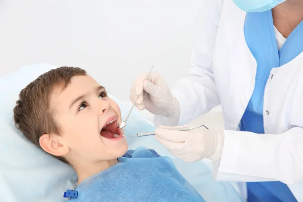 现代临床检查可爱男孩牙齿的牙医 — 图库照片