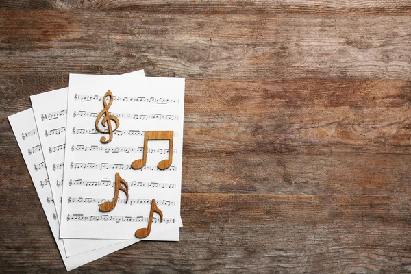 音乐笔记与板料在木背景 平的放置 文本的空间 — 图库照片