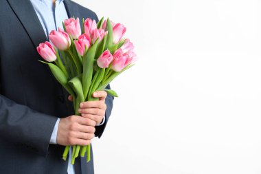 Açık renkli, tatlı güzel bahar lale buketi tutan şık elbiseli adam. Dünya Kadınlar günü