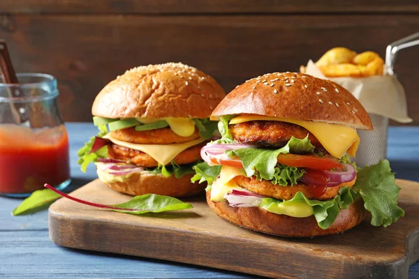 Wooden board with double vegetarian burgers on table