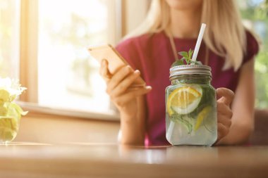 İçki masasında kafede güneşli gün, closeup serinletici kavanoz olan kadın. Metin için yer 