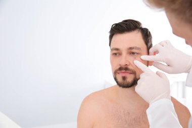 Hastanın doğum lekesi Kliniği inceleyerek dermatolog. Metin için yer
