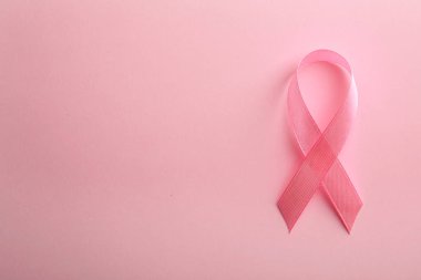 Renk arkaplan üzerine pembe kurdele, metin için boşluk ile üst görünüm. Göğüs kanseri farkındalığı konsepti