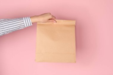 Kağıt torba renk arka plan üzerinde tutan kadın. Mockup tasarım için