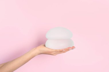 Silikon silikon tutan kadın ve göğüs büyütme renk arka plan, metin için yer için. Kozmetik cerrahi