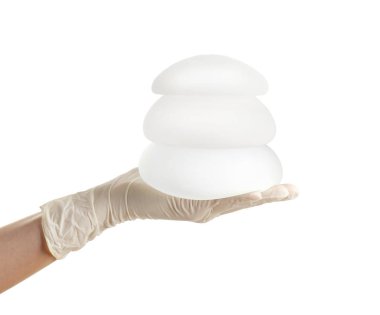 Beyaz arka plan üzerinde göğüs büyütme için doktor holding silikon implantlar. Kozmetik cerrahi