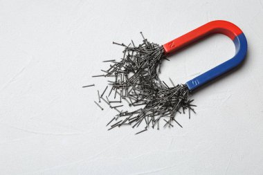 Açık renkli, metin için yer ile üstten görünüm üzerinde çivi çeken mıknatıs