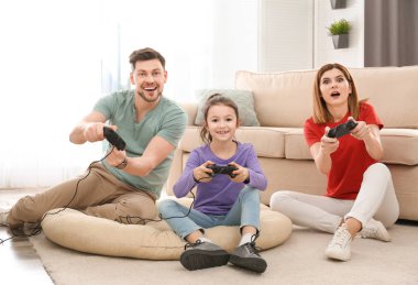 Mutlu aile oturma odasında video oyunları oynarken