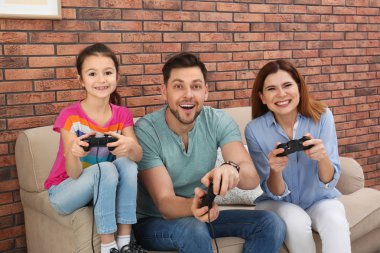 Mutlu aile oturma odasında video oyunları oynarken