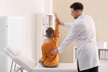Chiropractor inceleyerek çocuk kliniğinde bel ağrısı ile