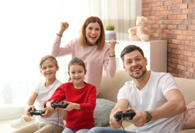 Mutlu aile oturma odasında video oyunları oynarken