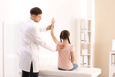 Chiropractor inceleyerek çocuk kliniğinde bel ağrısı ile