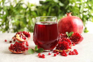 Composition with glass of fresh pomegranate juice on table clipart