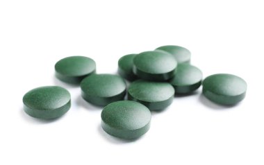 Beyaz arka plan üzerinde Spirulina tabletleri. Sağlıklı yaşam tarzı