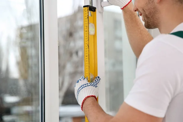 Byggnadsarbetare Med Vattenpass När Installerar Fönster Inomhus Närbild — Stockfoto