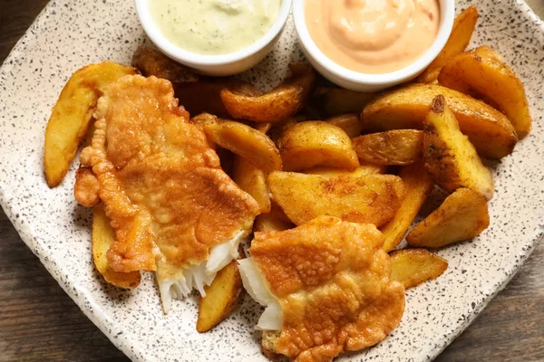 Plate with British traditional fish and potato chips, top view