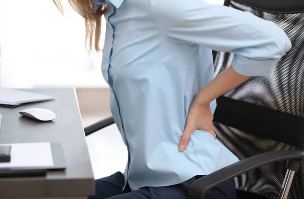 クローズ アップのオフィスで背中の痛みから苦しんでいる若い女性 — ストック写真