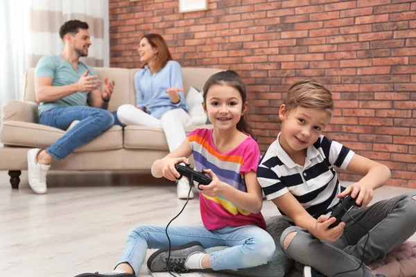 Милые Дети Играют Видеоигры Пока Родители Отдыхают Диване Дома — стоковое фото