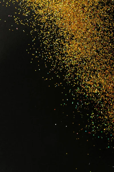 Gold glitter on black background, top view with space for text