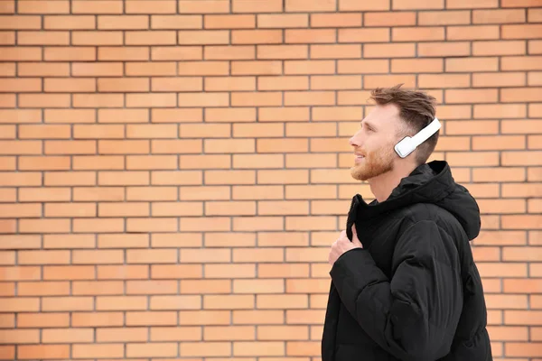 Joven Escuchando Música Con Auriculares Contra Pared Ladrillo Espacio Para — Foto de Stock