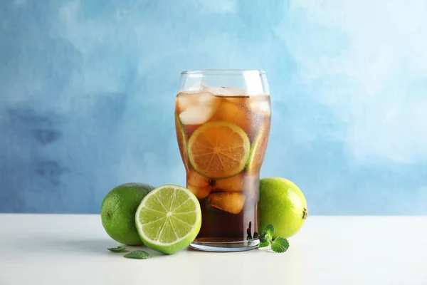 Glas Van Cokes Met Ijsblokjes Limoenen Tafel Tegen Een Achtergrond — Stockfoto
