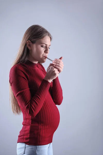 灰色の背景の若い妊婦喫煙タバコ 胎児に害を与える — ストック写真