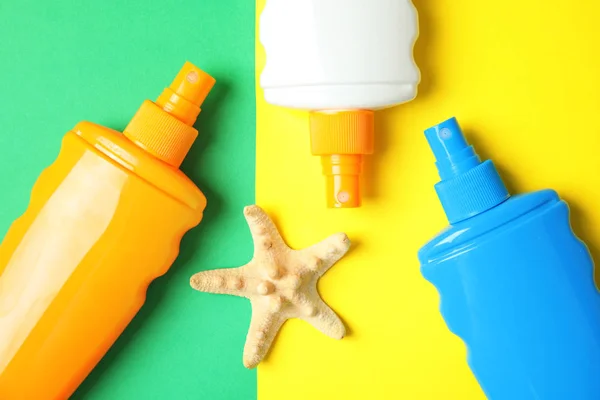 Flaschen Mit Sonnenschutzmitteln Und Seesternen Auf Farbigem Hintergrund Flache Lage — Stockfoto