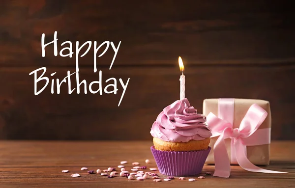 美味的纸杯蛋糕与蜡烛和礼品盒的木背景 生日快乐 — 图库照片