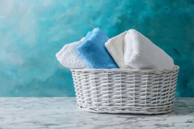 Sepet ile mavi arka plan, metin için yer karşı masada renkli temiz yumuşak havlu 