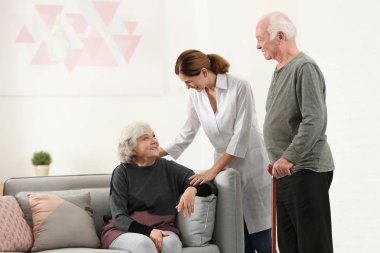 Yaşlı eş ile oturma odasında kadın caregiver
