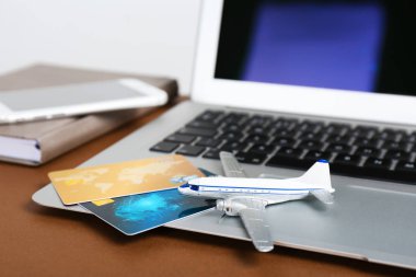 Dizüstü bilgisayar, oyuncak uçak ve kredi kartları masaya kompozisyonu. Seyahat Acentası