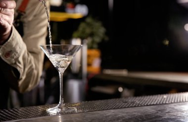 Barmen soğuk martini cam üstünde sayaç, closeup içine dökme. Metin için yer