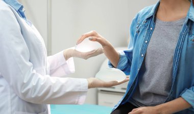 Göğüs büyütme için hastada klinik, closeup için doktor gösteren silikon implantlar. Kozmetik cerrahi