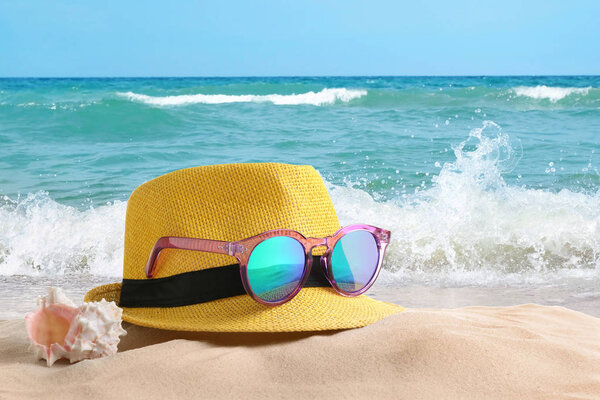Вид на океанский песчаный пляж и шляпа с солнцезащитными очками
