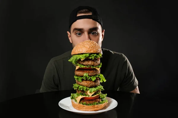 Jovem Com Fome Homem Enorme Hambúrguer Fundo Preto — Fotografia de Stock