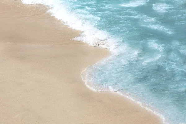 美丽的蓝色波浪与海泡沫在沙滩上 — 图库照片